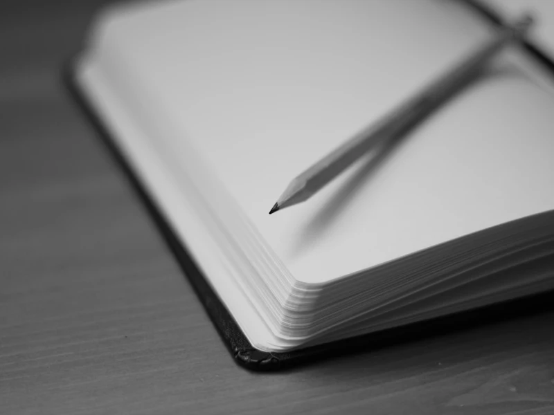A pencil resting on an open notebook