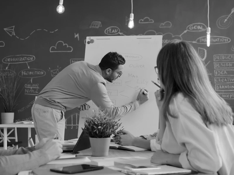 A man presenting ideas on a whiteboard to colleagues